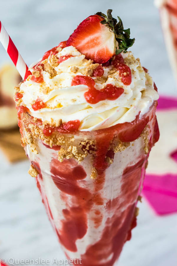 Strawberry Cheesecake Milkshake with Cream Cheese Whipped Cream and strawberries on top