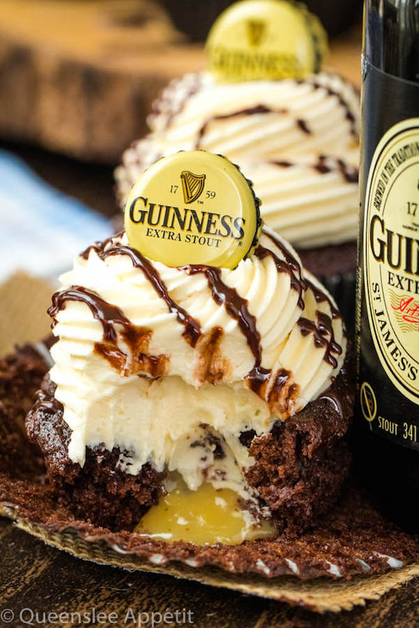 Guinness Chocolate Cupcakes with Baileys Buttercream Frosting, Guinness ganache drizzle and beer bottle cap on top and a Baileys ganache filling