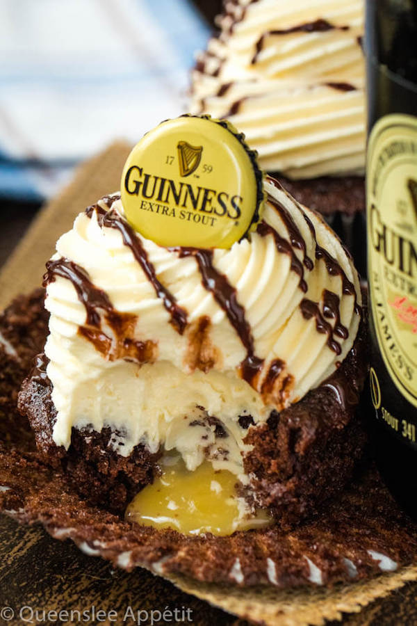 Guinness Chocolate Cupcakes with Baileys Buttercream Frosting, Guinness ganache drizzle and beer bottle cap on top and a Baileys ganache filling