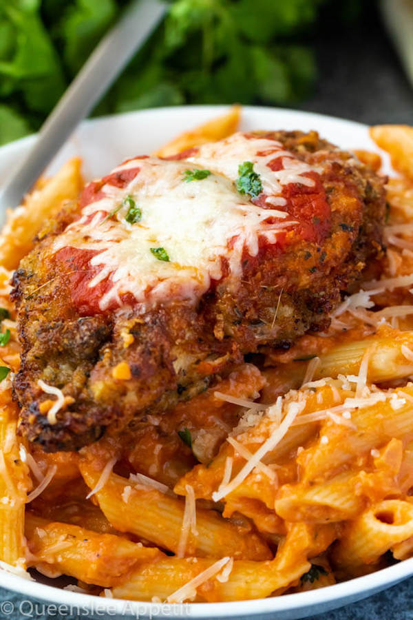 crispy chicken parmesan on a plate of penne alla vodka 