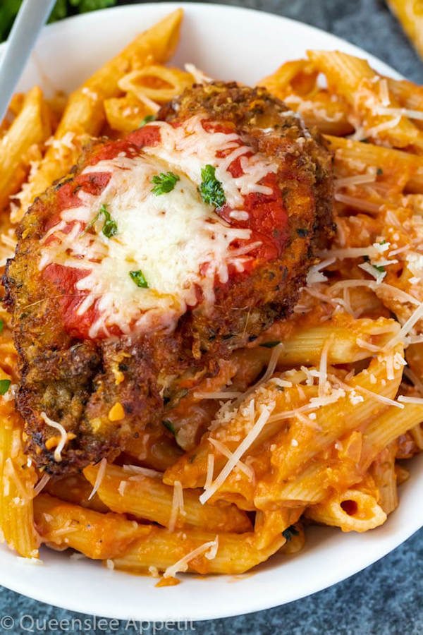 crispy chicken parmesan on a plate of penne alla vodka 