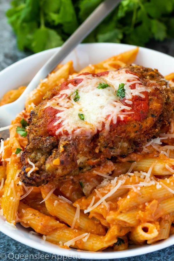 crispy chicken parmesan on a plate of penne alla vodka 