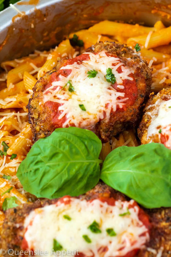 crispy chicken parmesan in a pot of penne alla vodka with basil leaf garnish