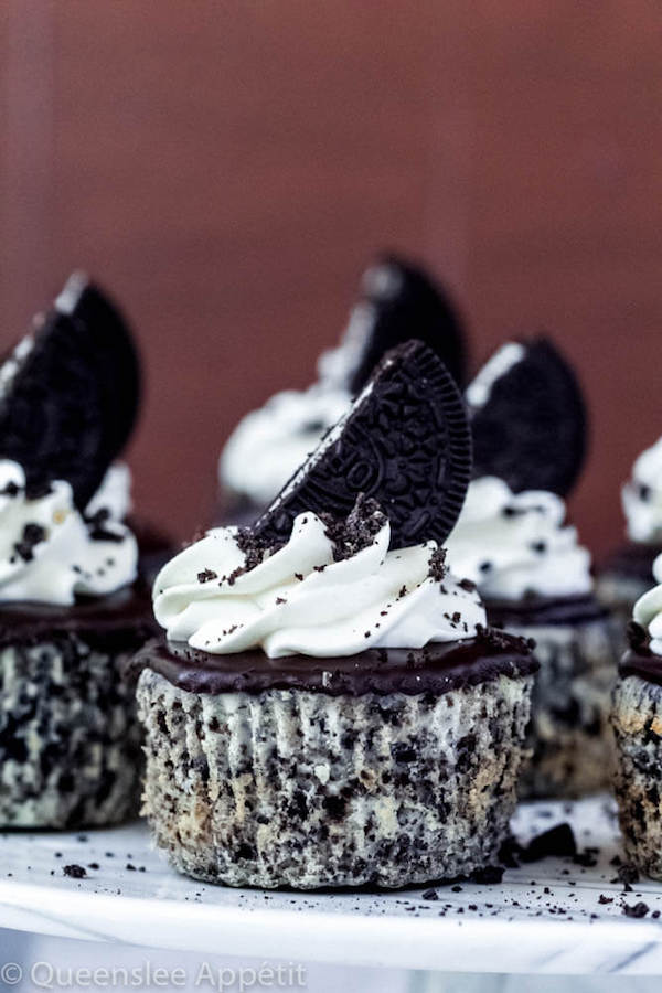 mini cookies and cream cheesecakes on a cake stand