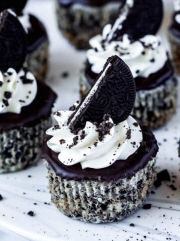 mini cookies and cream cheesecakes on a cake stand