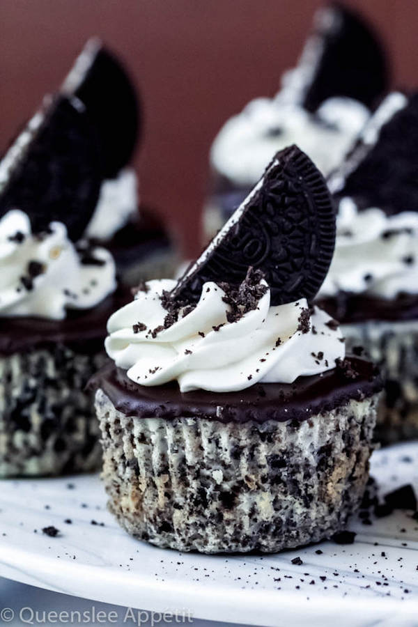 mini cookies and cream cheesecakes on a cake stand