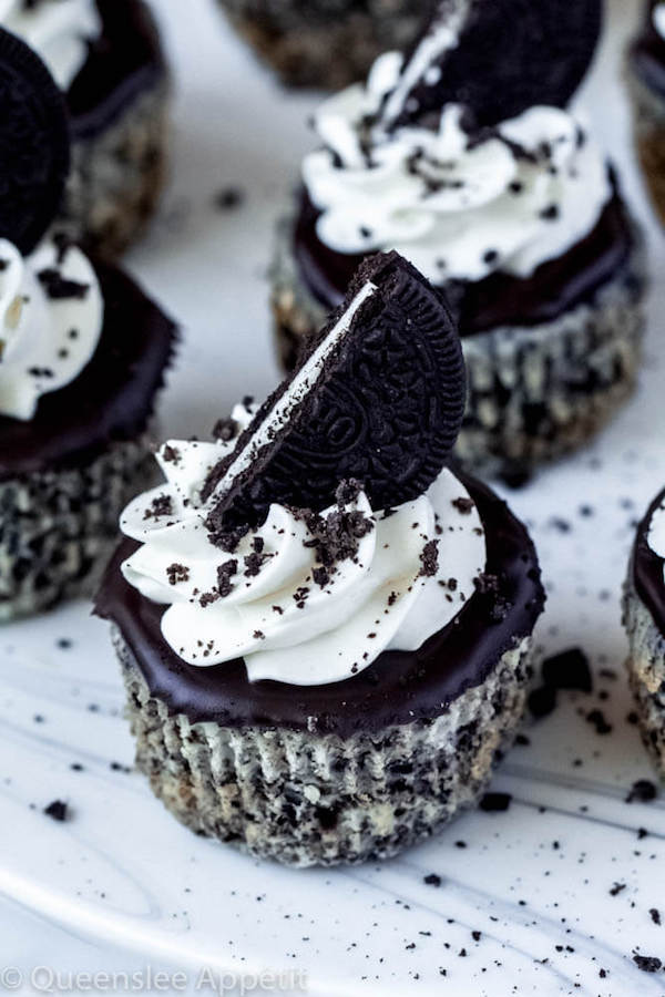 mini cookies and cream cheesecakes on a cake stand