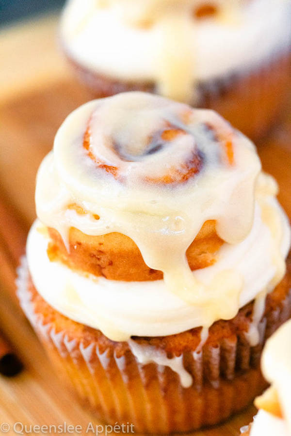 cinnamon roll cupcakes with cream cheese frosting and a glazed mini cinnamon roll on top