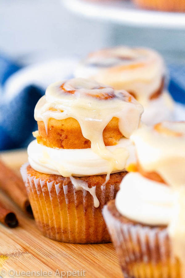 cinnamon roll cupcakes with cream cheese frosting and a glazed mini cinnamon roll on top