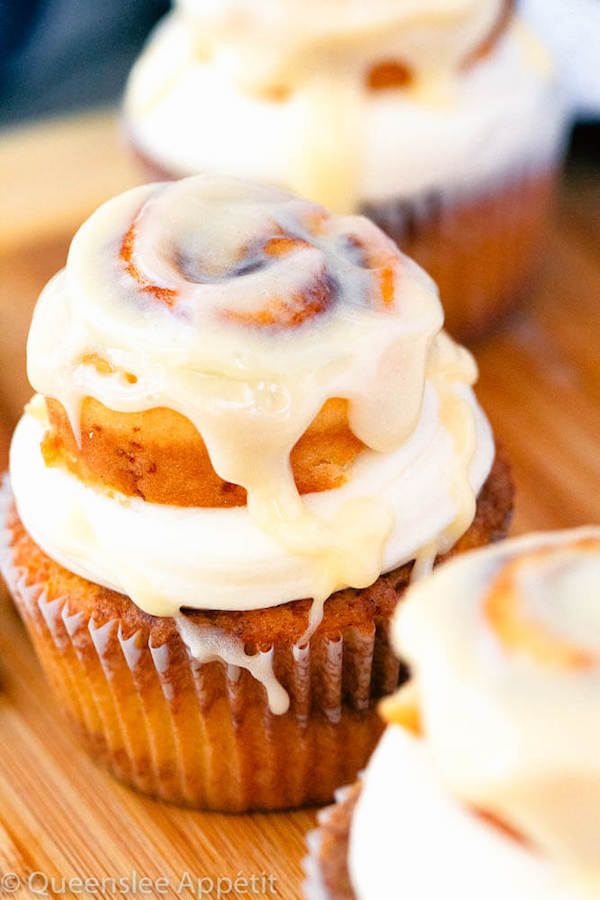 cinnamon roll cupcakes with cream cheese frosting and a glazed mini cinnamon roll on top