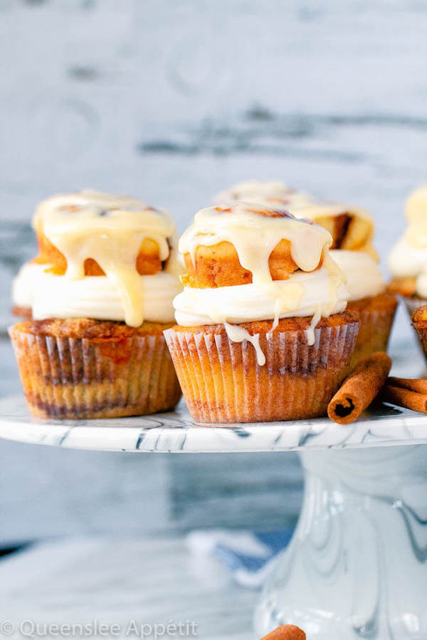 cinnamon roll cupcakes with cream cheese frosting and a glazed mini cinnamon roll on top