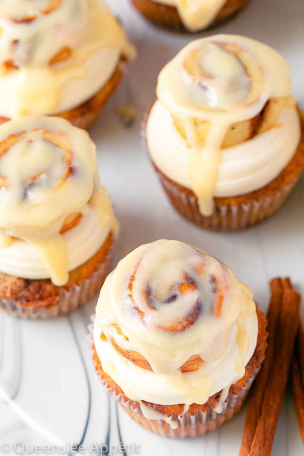 cinnamon roll cupcakes with cream cheese frosting and a glazed mini cinnamon roll on top