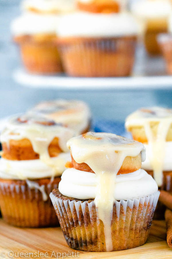 cinnamon roll cupcakes with cream cheese frosting and a glazed mini cinnamon roll on top