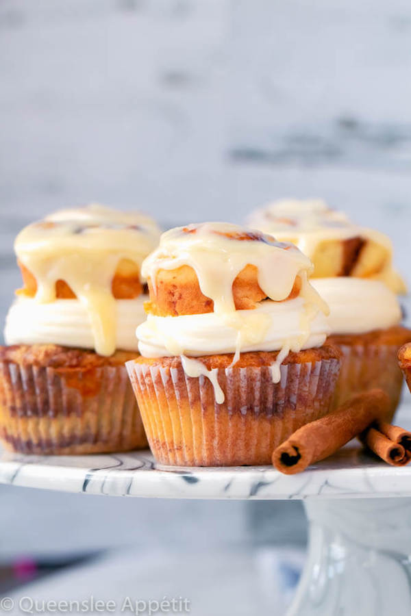 cinnamon roll cupcakes with cream cheese frosting and a glazed mini cinnamon roll on top