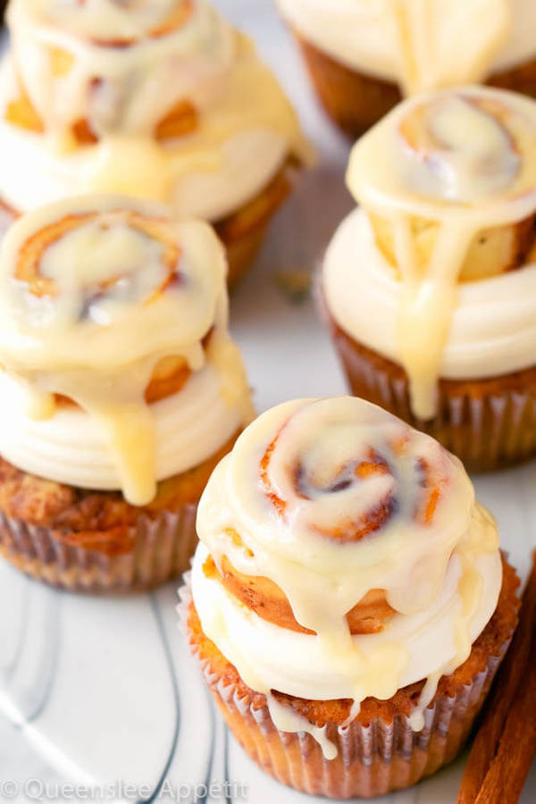 cinnamon roll cupcakes with cream cheese frosting and a glazed mini cinnamon roll on top