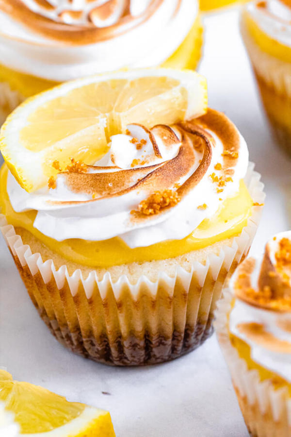 Lemon cupcakes with graham cracker crust, toasted marshmallow filling, lemon curd topping, meringue frosting and a lime and graham cracker crumbs on top