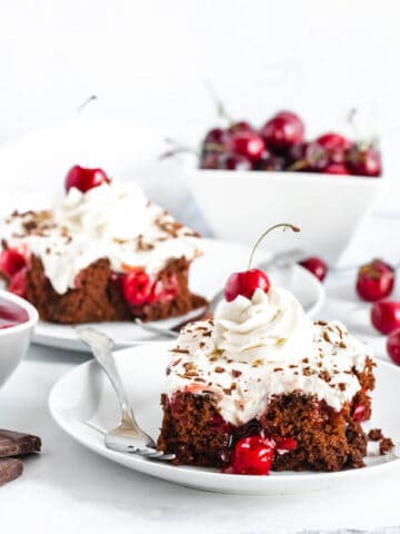 chocolate cake filled with cherry pie filling and topped with whipped cream, chocolate shavings and a cherry