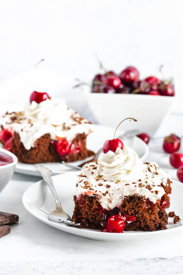 chocolate cake filled with cherry pie filling and topped with whipped cream, chocolate shavings and a cherry