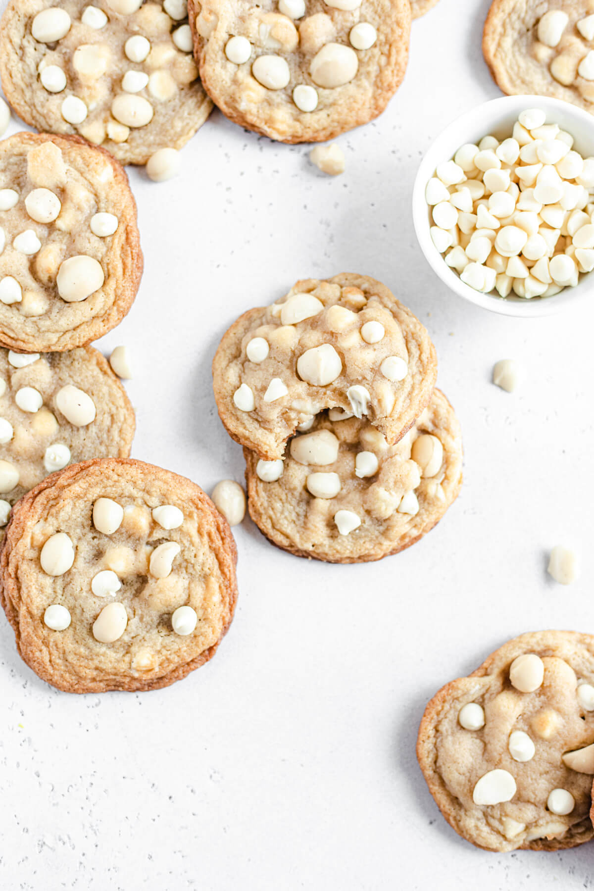 white chocolate and macadamia nut cookies with a bowl of white chocolate chips next to them