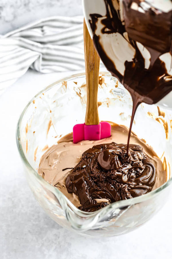 pouring melted chocolate into chocolate cheesecake batter