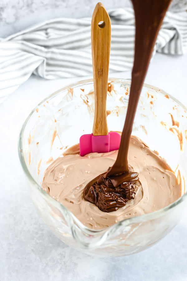 pouring melted chocolate into cheesecake batter