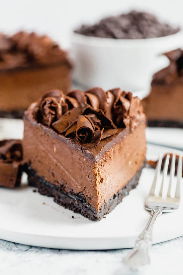 chocolate cheesecake baked in an Oreo crust topped with chocolate ganache, chocolate whipped cream, cocolate shards and a dust of cocoa powder.