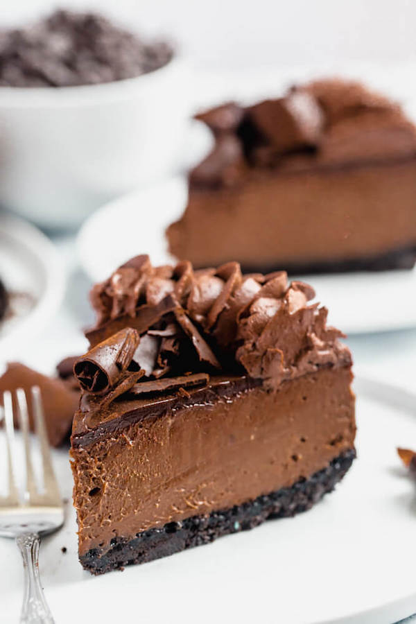 chocolate cheesecake baked in an Oreo crust topped with chocolate ganache, chocolate whipped cream, cocolate shards and a dust of cocoa powder.