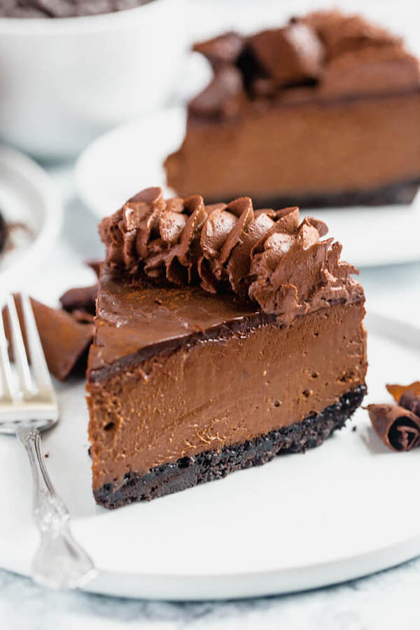 chocolate cheesecake baked in an Oreo crust topped with chocolate ganache, chocolate whipped cream, cocolate shards and a dust of cocoa powder.