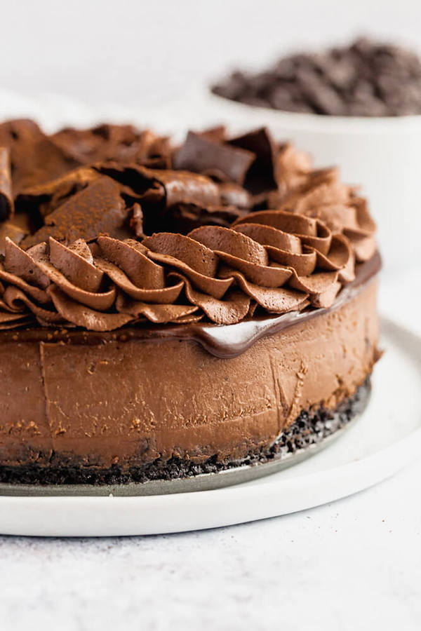 chocolate cheesecake baked in an Oreo crust topped with chocolate ganache, chocolate whipped cream, cocolate shards and a dust of cocoa powder.