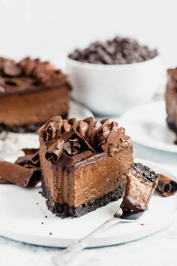 chocolate cheesecake baked in an Oreo crust topped with chocolate ganache, chocolate whipped cream, cocolate shards and a dust of cocoa powder.