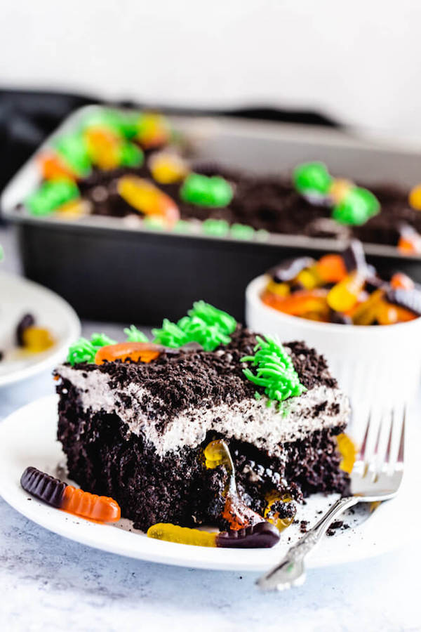 dark chocolate cake filled with chocolate pudding, Oreo crumbs, gummy worms and topped with Oreo cream cheese frosting, green grass buttercream and more Oreo crumbs and gummy worms