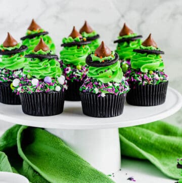 black chocolate cupcakes topped with green buttercream and witch hats