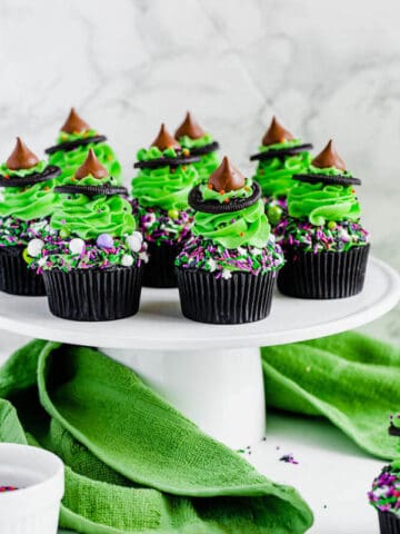 black chocolate cupcakes topped with green buttercream and witch hats