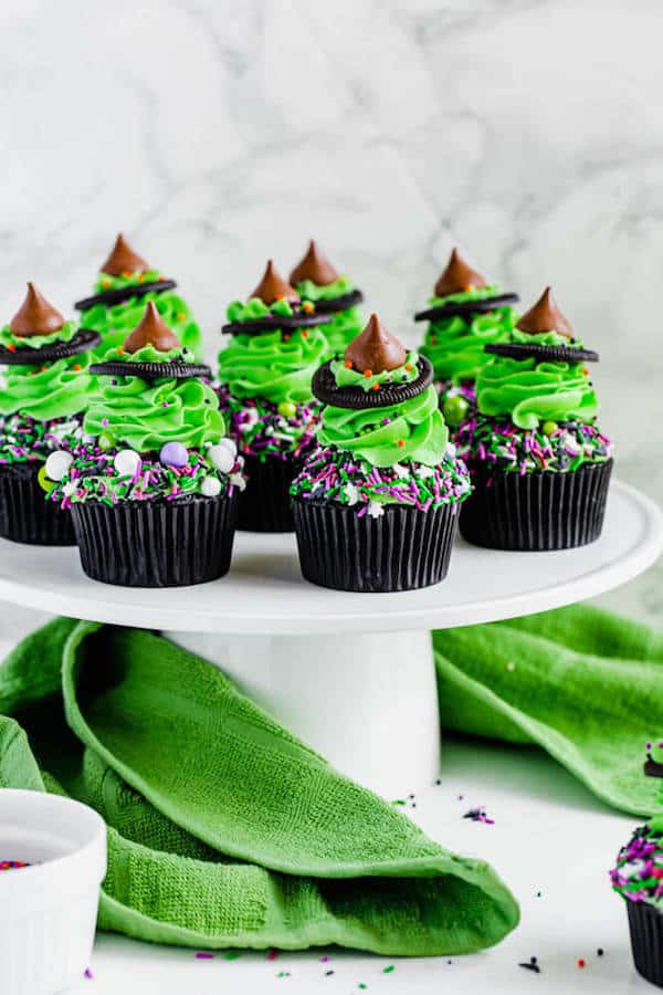black chocolate cupcakes topped with green buttercream and witch hats