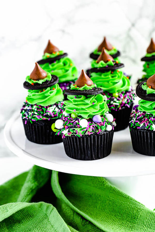 black chocolate cupcakes topped with green buttercream and witch hats