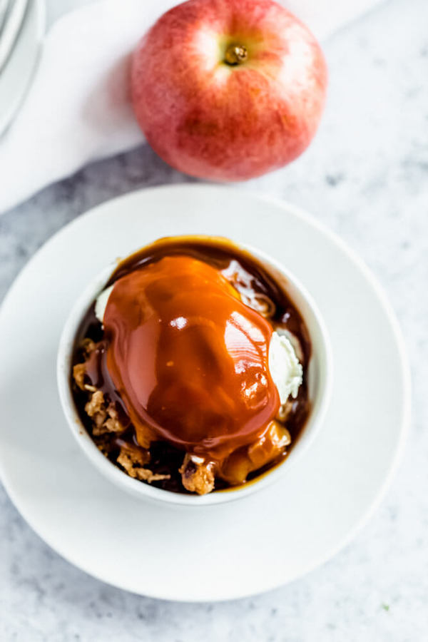 apple crisp topped with vanilla ice cream and salted caramel sauce