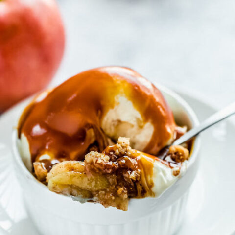 apple crisp topped with vanilla ice cream and salted caramel sauce