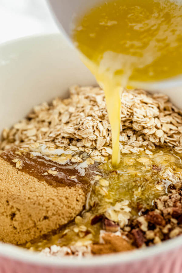 pouring melted butter into crumble ingredients