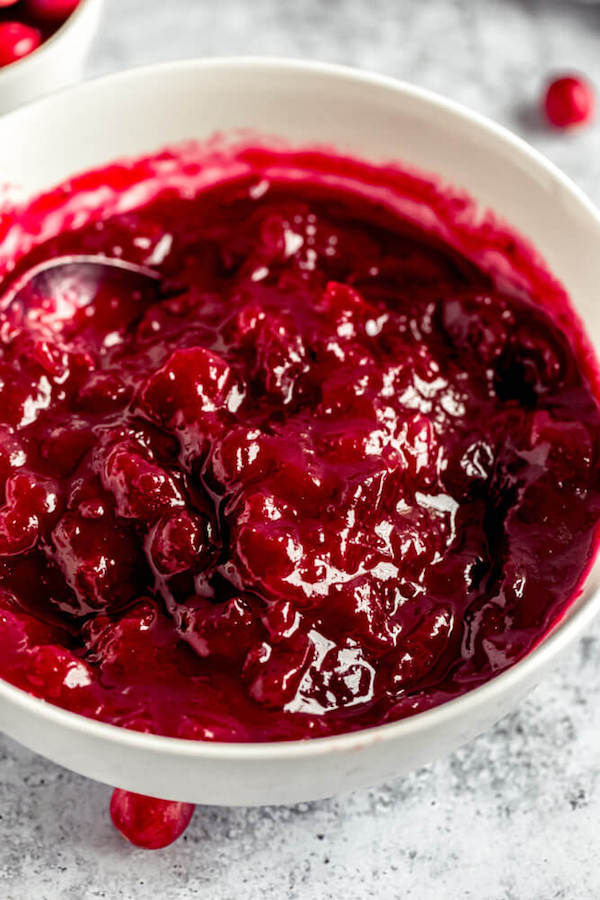 homemade cranberry sauce in a bowl with a spoon