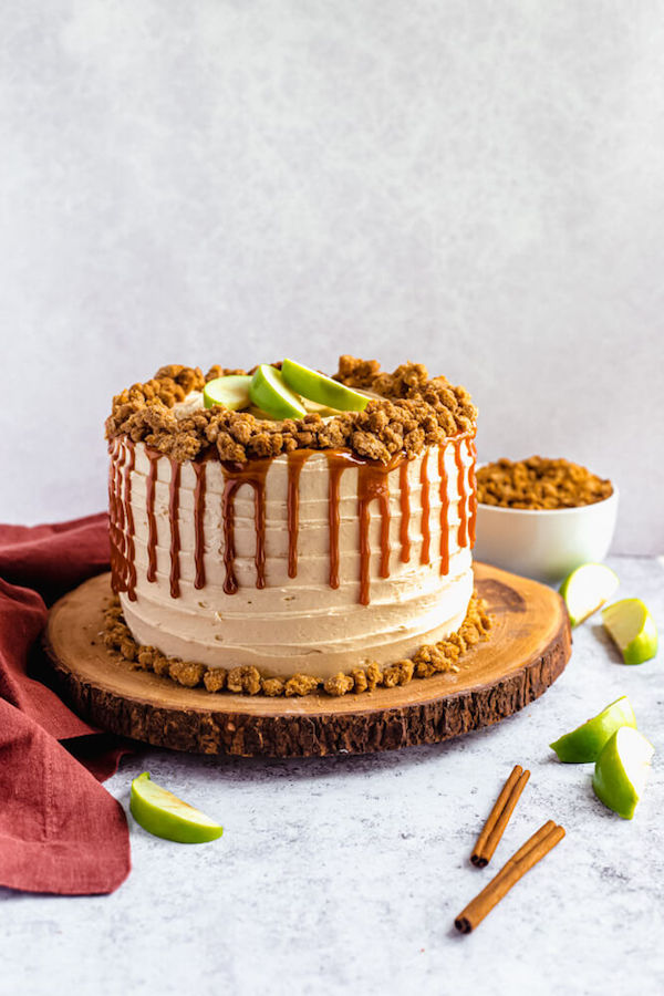 caramel apple crumble cake on a wooden cake stand