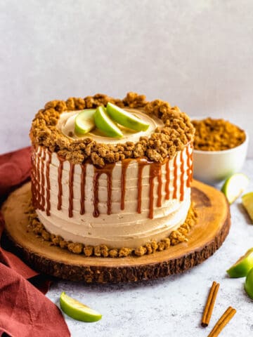 caramel apple crumble cake on a wooden cake stand