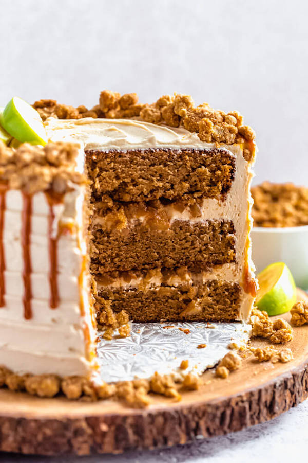 caramel apple crumble cake cut open on a wooden cake stand