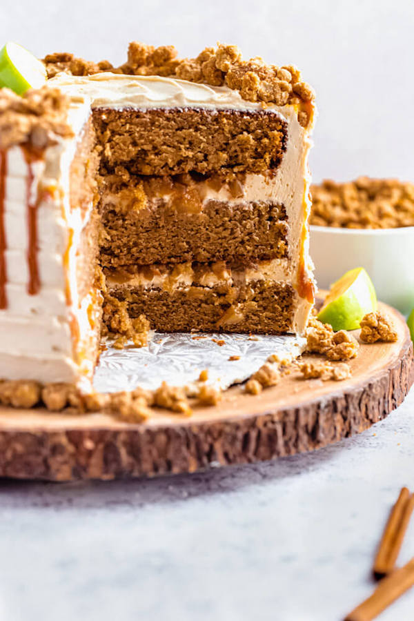 caramel apple crumble cake cut open on a wooden cake stand