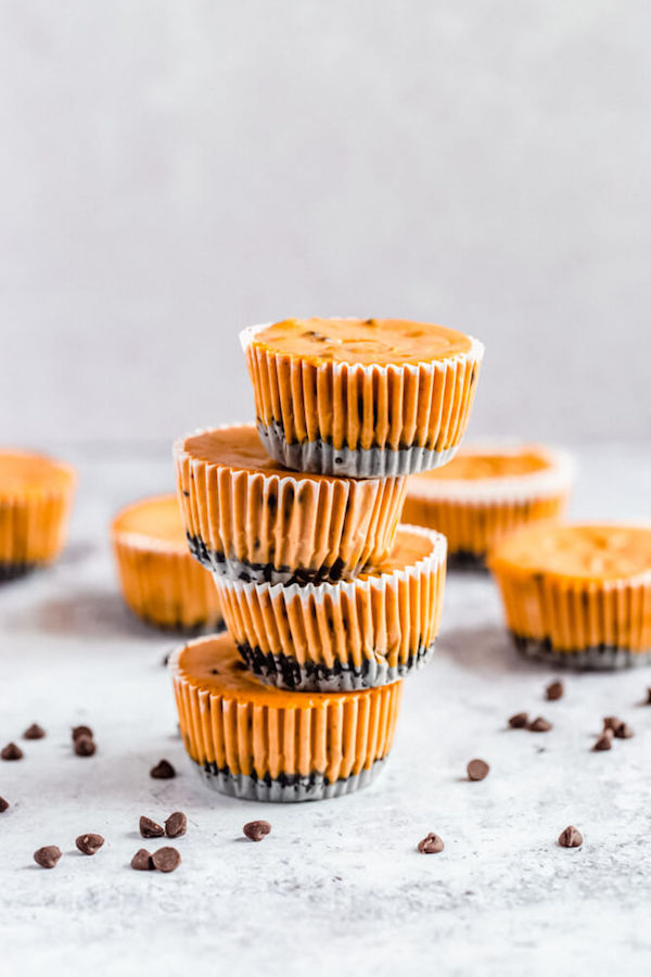 un-decorated mini pumpkin cheesecakes stacked on top of each other