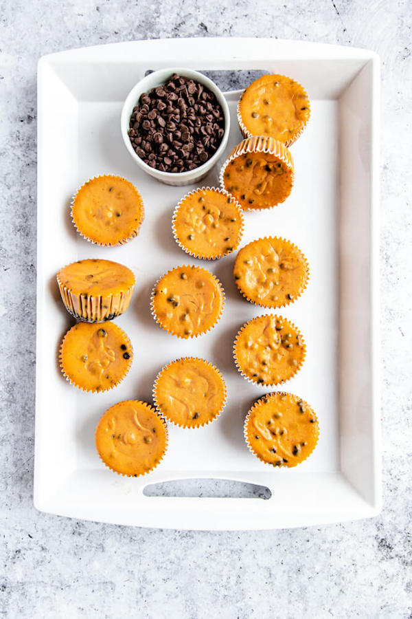 undecorated pumpkin cheesecakes on a white tray