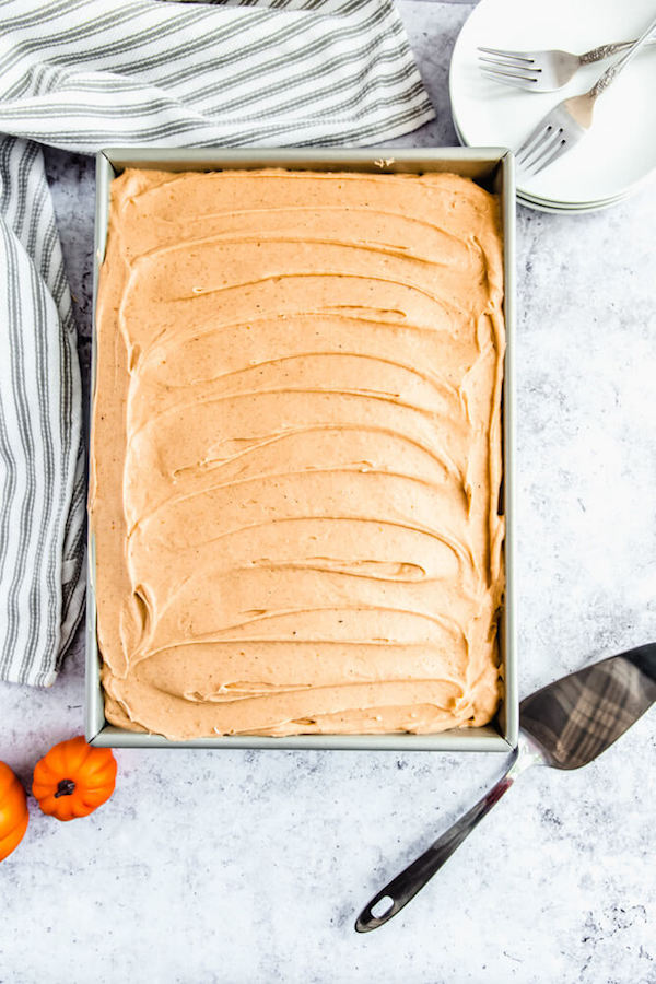 caramel pumpkin spice cream cheese frosting spread on pumpkin cake