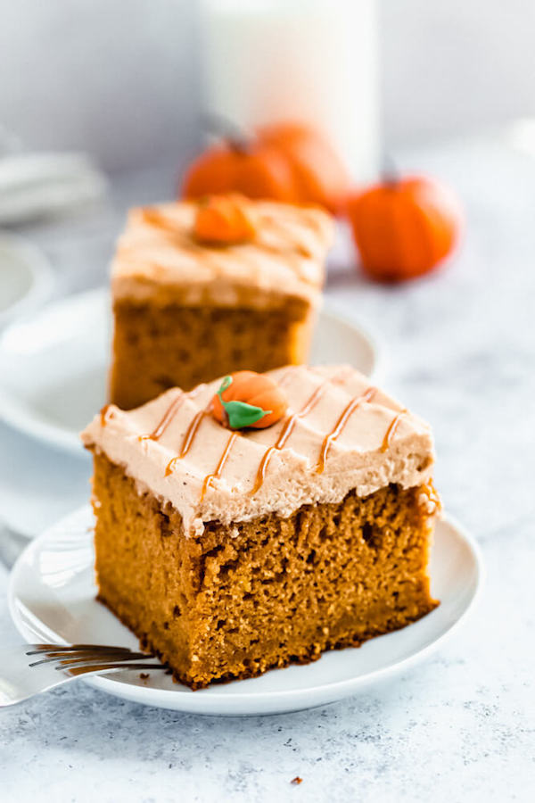 slice of pumpkin cake topped with caramel pumpkin spice cream cheese frosting