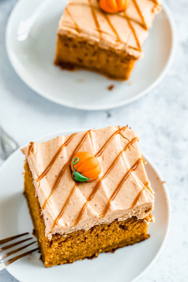 slice of pumpkin cake topped with caramel pumpkin spice cream cheese frosting