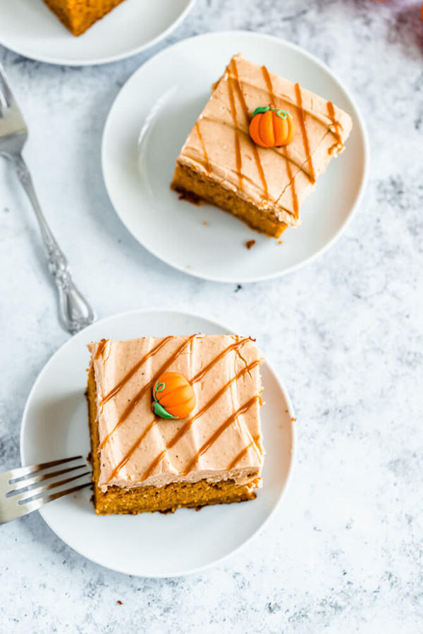 slice of pumpkin cake topped with caramel pumpkin spice cream cheese frosting