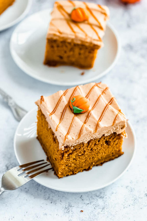 slice of pumpkin cake topped with caramel pumpkin spice cream cheese frosting